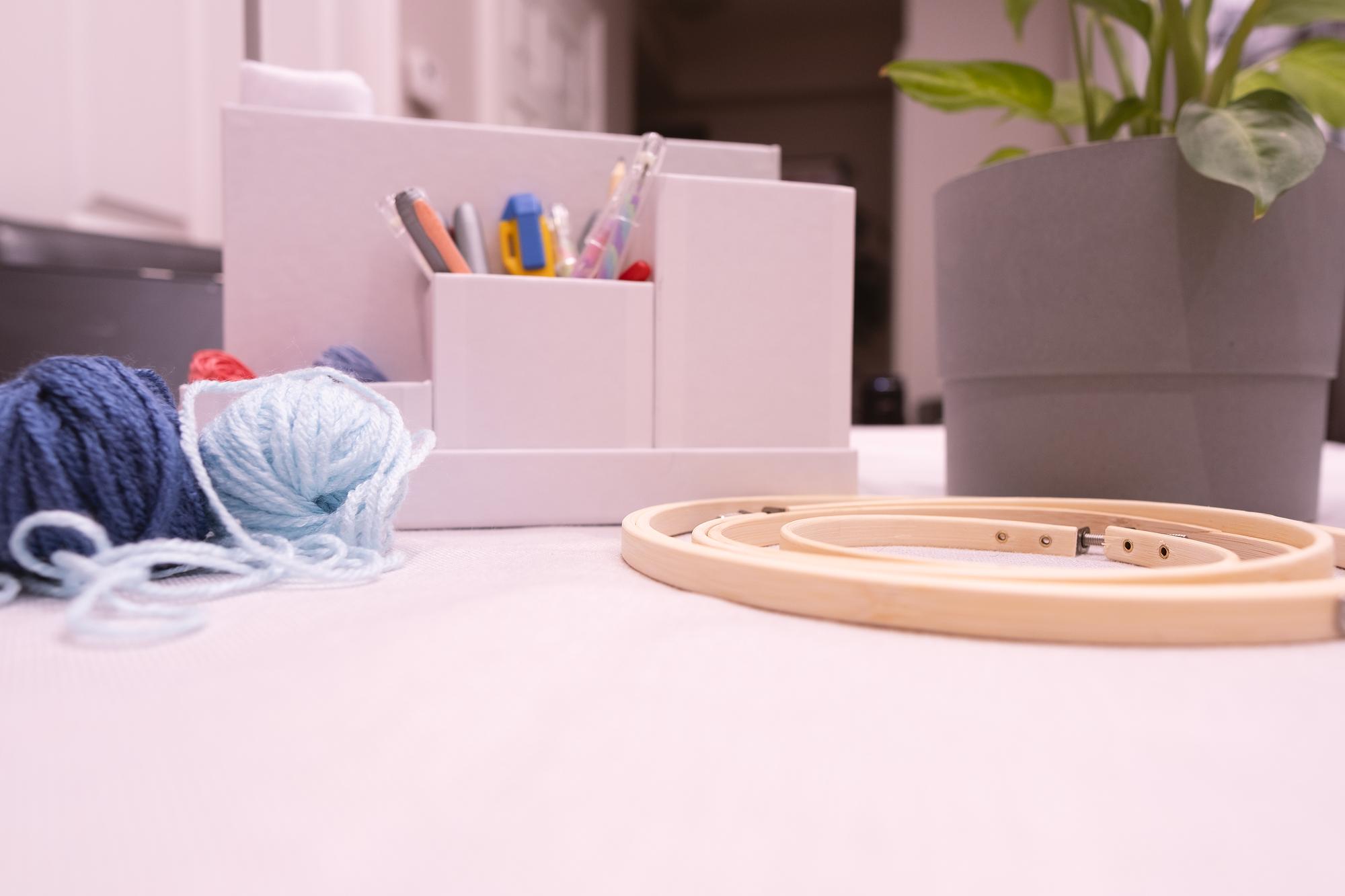 Studio con strumenti da ricamo su tavolo di legno